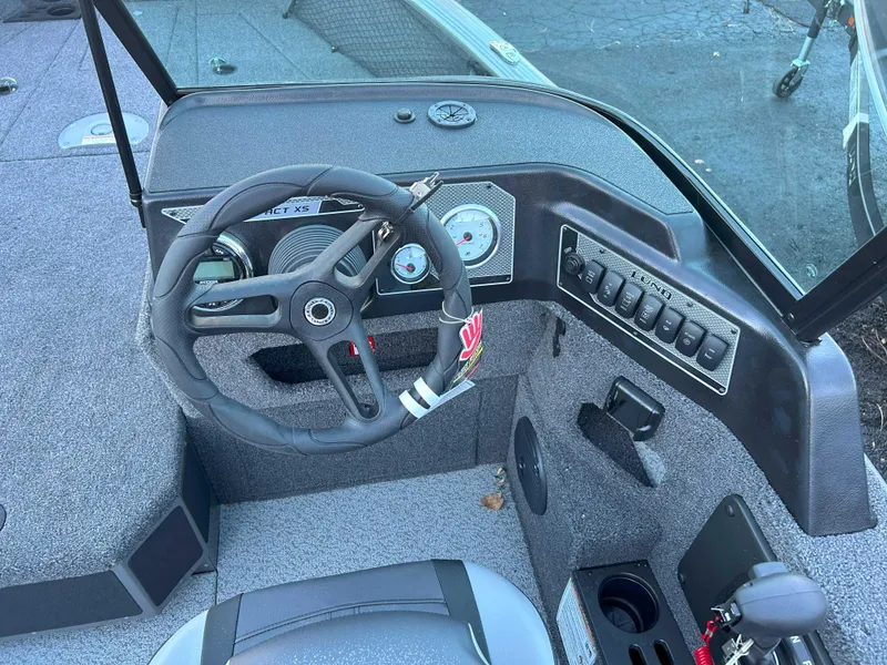 Slide: The Image of 2025 Lund 1875 Impact XS boat dashboard with steering wheel and control panel. - 6