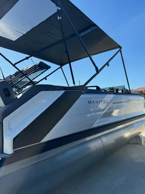 Slide: The Image of 2025 Manitou 22' Cruise Bench Twin Tube pontoon boat with canopy, side view. - 1
