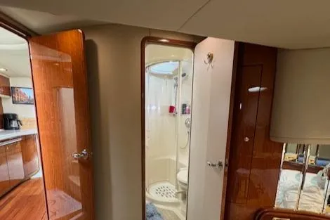 Slide: The Image of Interior of 2001 Sea Ray Sundancer 540 yacht, featuring a compact bathroom and wooden cabinetry. - 24