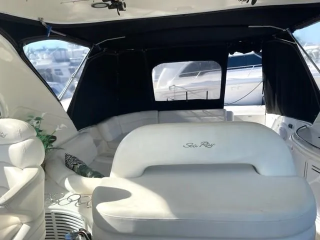 Slide: The Image of Interior of a 2001 Sea Ray Sundancer 540 yacht with white seating and black canopy. - 28