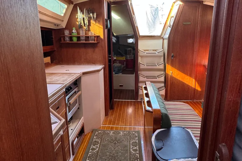 Slide: The Image of Interior of a 1989 Catalina 42 sailboat with wood finishes and compact kitchen. - 1