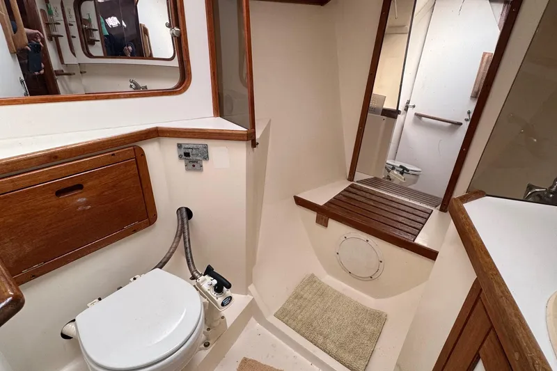 Slide: The Image of Bathroom interior of a 1989 Catalina 42 sailboat, featuring wooden accents and compact design. - 11