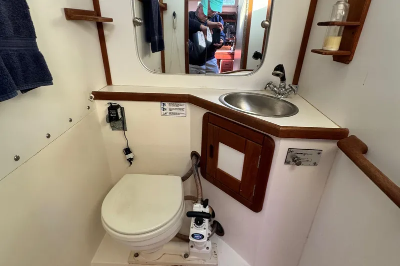 Slide: The Image of 1989 Catalina 42 yacht bathroom with toilet, sink, and mirror. - 12