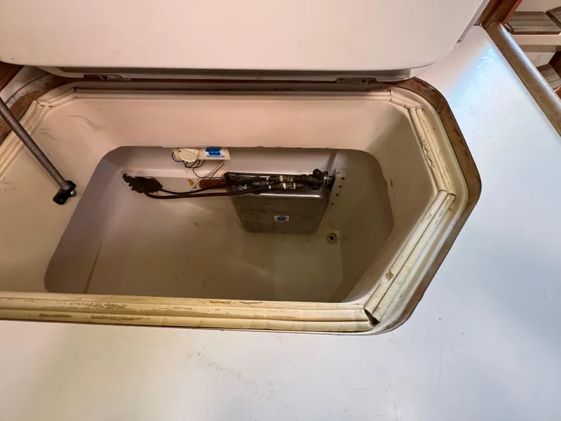 Slide: The Image of Open storage compartment in 1989 Catalina 42 sailboat, showing interior space and equipment. - 16