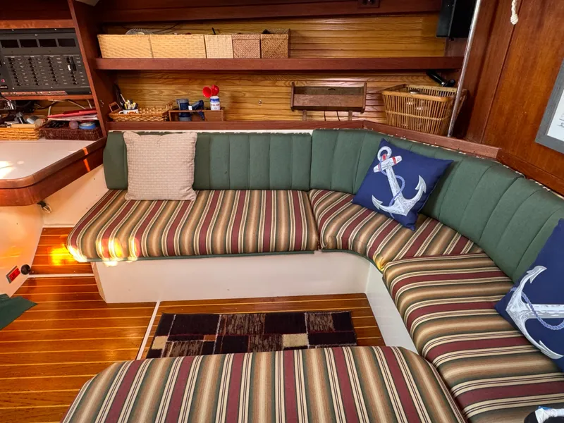 Slide: The Image of Cozy interior of 1989 Catalina 42 sailboat with striped seating and nautical-themed pillows. - 2