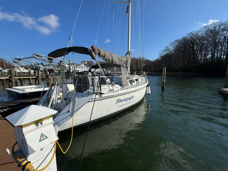 Slide: The Image of 1989 Catalina 42 sailboat docked in a marina under a clear blue sky. - 21