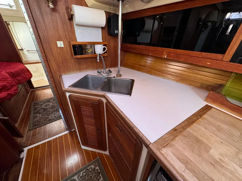 Slide: The Image of 1989 Catalina 42 yacht interior with wooden cabinetry and dual sink in the galley. - 4