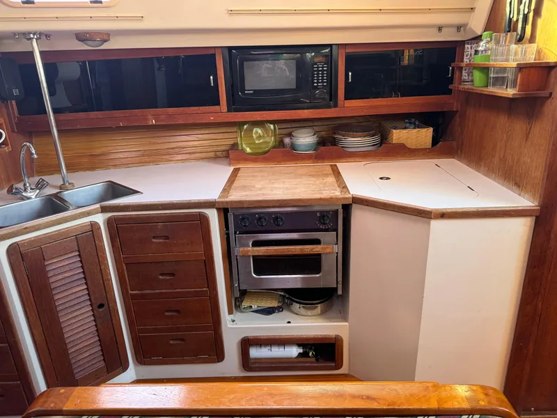 Slide: The Image of Galley kitchen in 1989 Catalina 42 sailboat with wood cabinetry and modern appliances. - 6