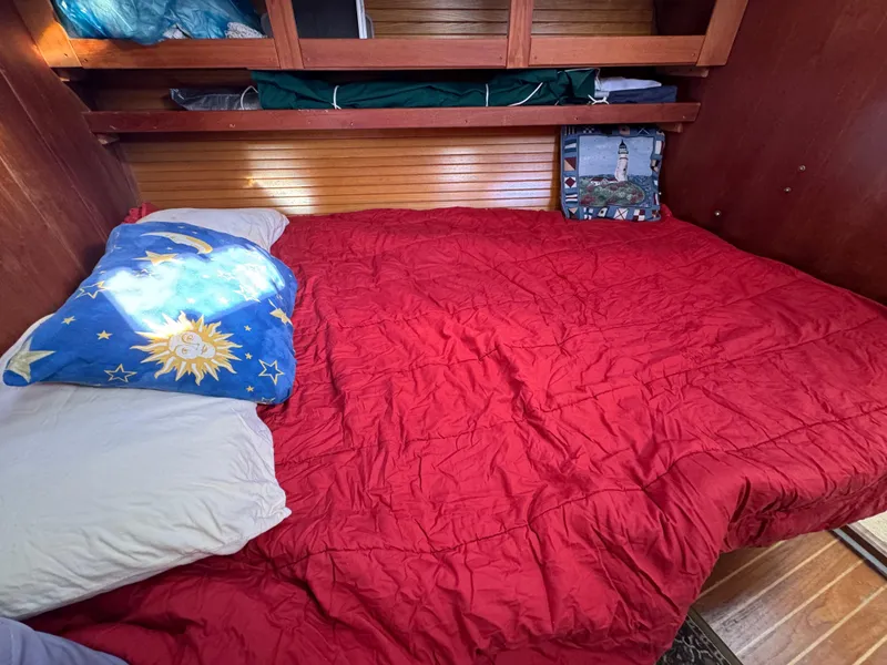 Slide: The Image of Cozy cabin bed in 1989 Catalina 42 sailboat with red bedding and decorative pillows. - 8