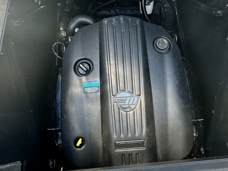 Slide: The Image of 2023 Malibu M220 engine compartment with black cover and visible branding. - 16