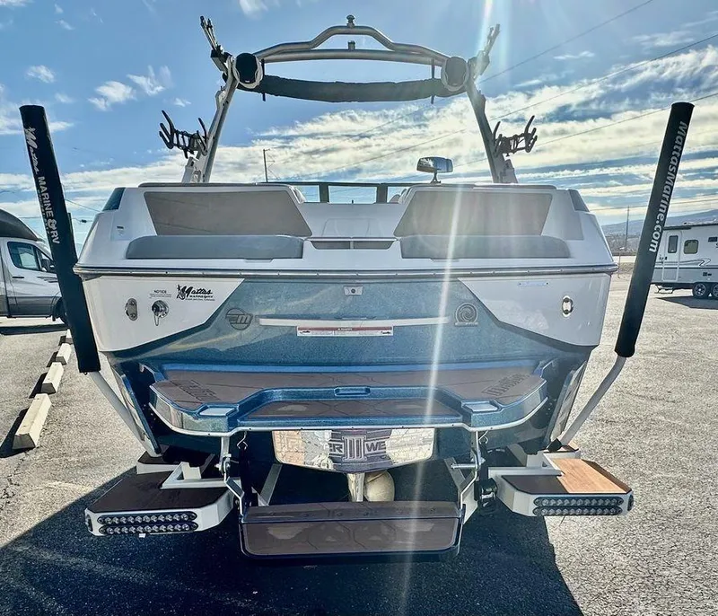 Slide: The Image of 2023 Malibu M220 boat rear view with sunlit details and sleek design. - 4