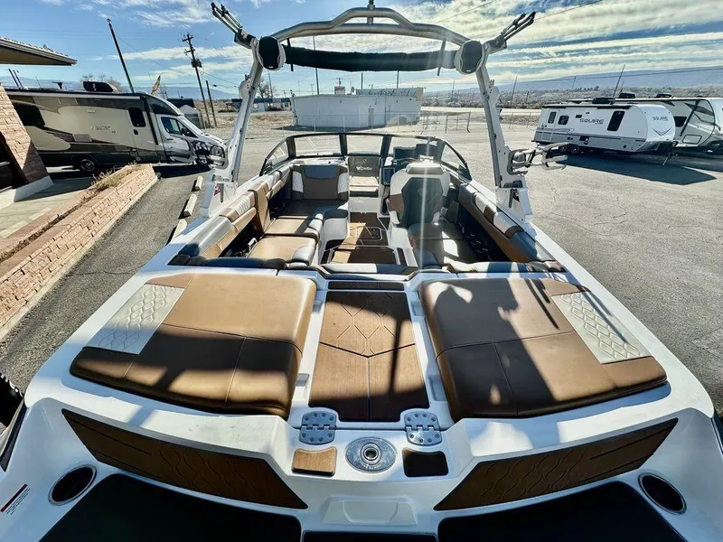 Slide: The Image of 2023 Malibu M220 boat with spacious seating and sleek design in a sunny outdoor setting. - 8