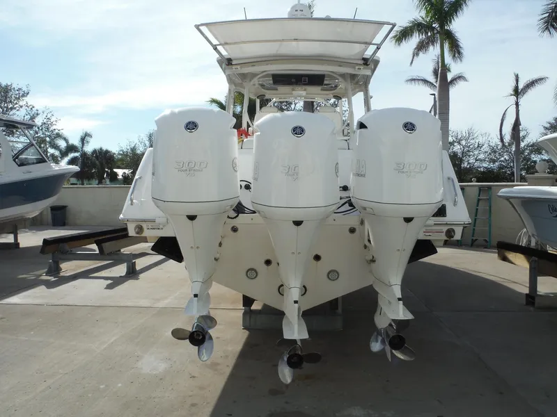 Slide: The Image of 2017 Everglades 360LXC boat with triple outboard engines, docked outdoors. - 11