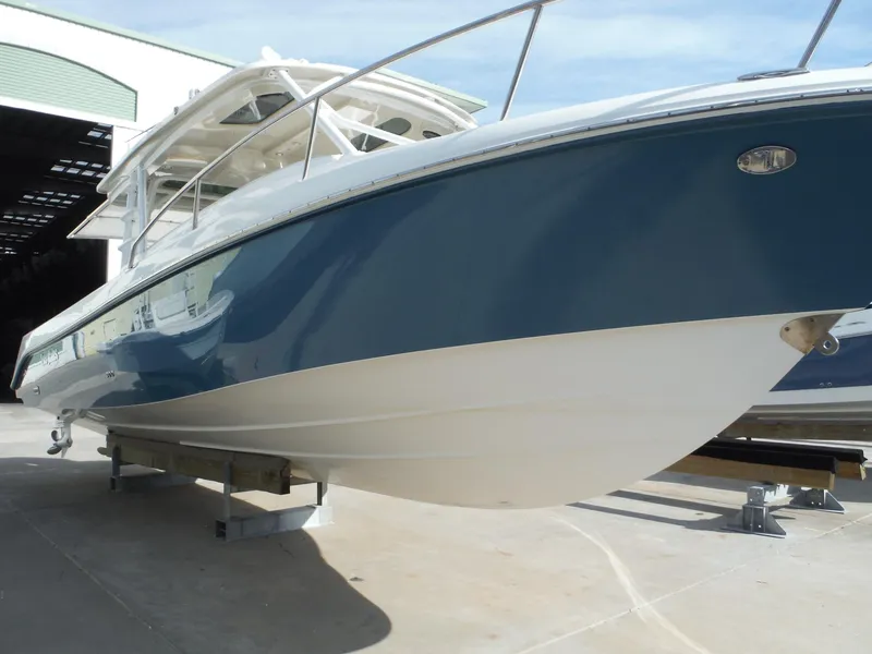 Slide: The Image of 2017 Everglades 360LXC boat with sleek blue and white hull in a marina setting. - 13