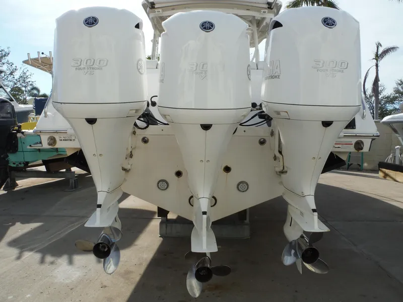 Slide: The Image of Triple outboard engines on a 2017 Everglades 360LXC boat, docked on a sunny day. - 17