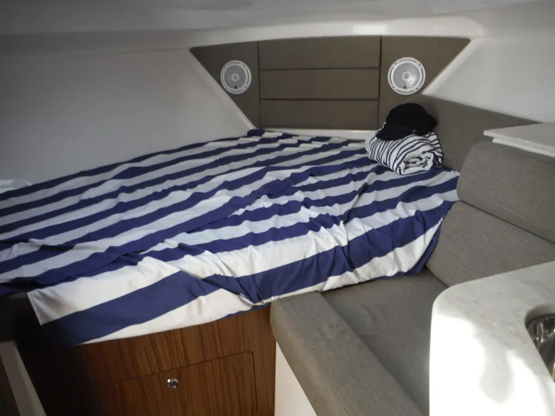 Slide: The Image of Cozy cabin interior of 2017 Everglades 360LXC with striped bedding and seating. - 32