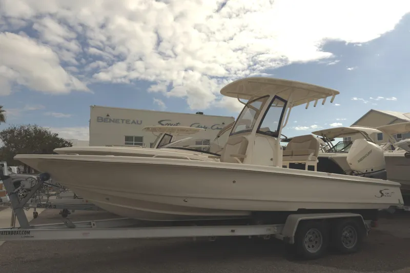 Slide: The Image of 2024 Scout 231 XSB boat on trailer under cloudy sky. - 0