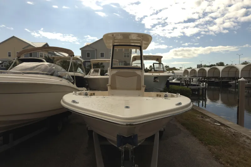 Slide: The Image of 2024 Scout 231 XSB boat docked at marina under a partly cloudy sky. - 1