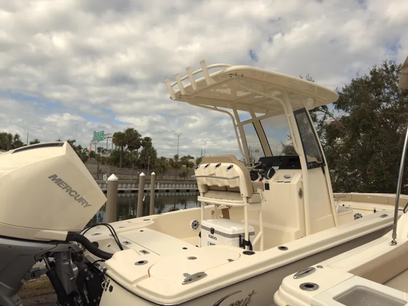 Slide: The Image of 2024 Scout 231 XSB boat with Mercury engine, docked under cloudy sky. - 2