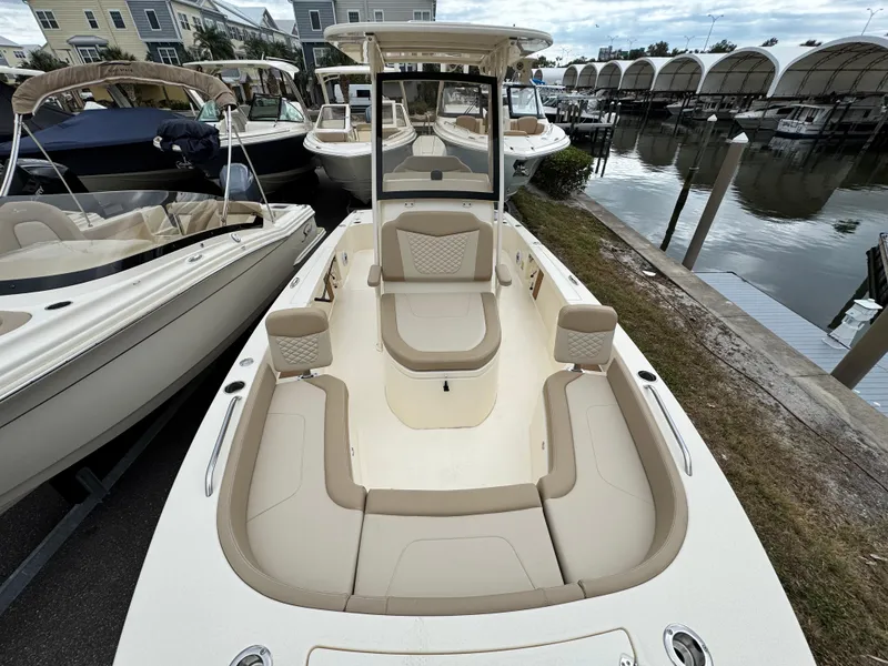Slide: The Image of 2024 Scout 231 XSB boat with spacious seating, docked near other boats. - 6