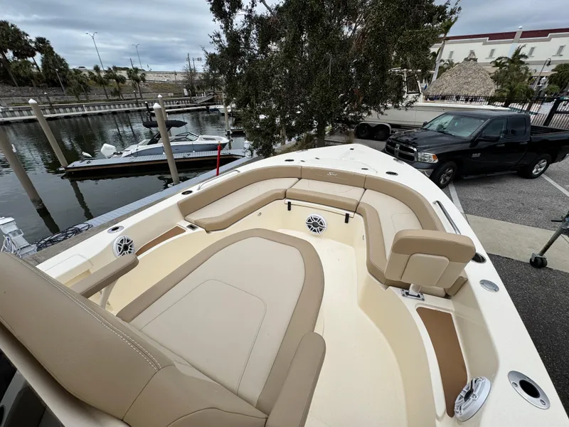 Slide: The Image of 2024 Scout 231 XSB boat with beige seating at a marina. - 7