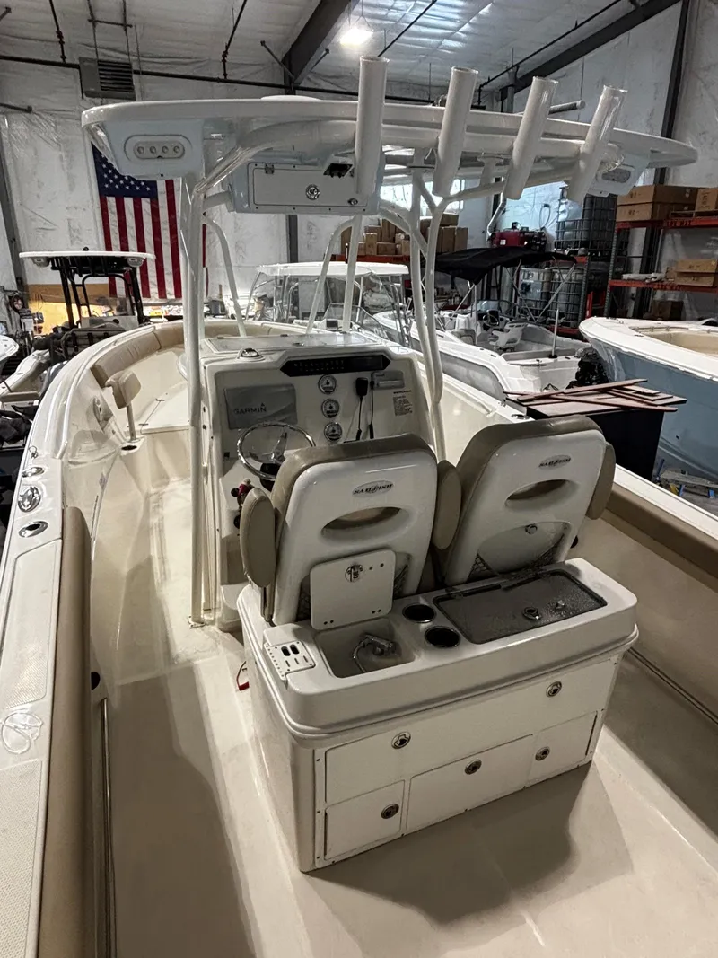 Slide: The Image of 2018 Sailfish 270 CC boat interior with helm and seating in a warehouse. - 2