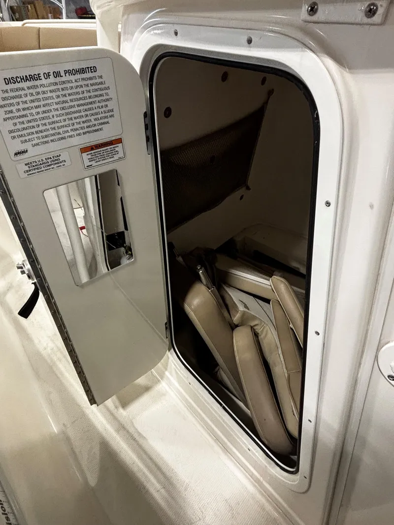 Slide: The Image of Open storage compartment on 2018 Sailfish 270 CC boat with folded seats inside. - 5