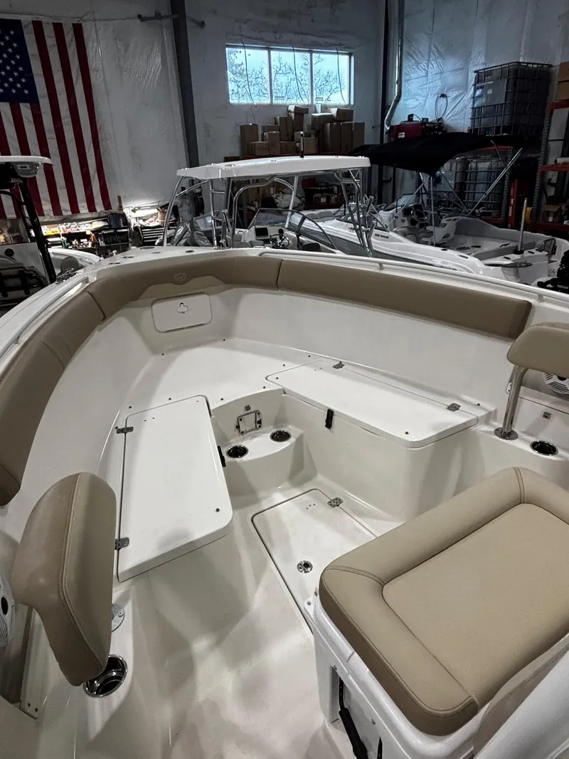 Slide: The Image of 2018 Sailfish 270 CC boat interior with beige seating in a warehouse setting. - 6