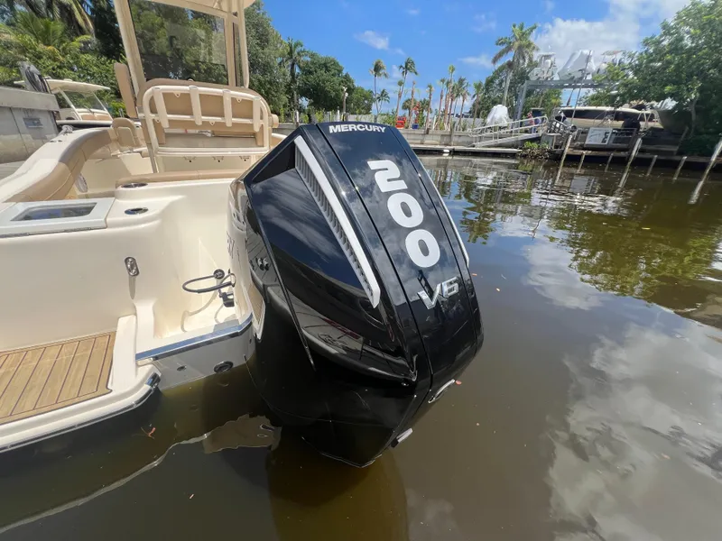 Slide: The Image of 2025 Scout 215 XSF boat with Mercury 200 V6 engine on calm water. - 13
