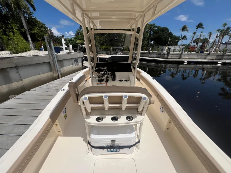 Slide: The Image of 2025 Scout 215 XSF boat interior at dock, featuring helm and seating. - 9
