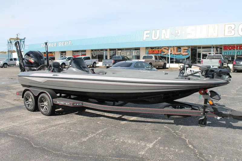 Slide: The Image of 2025 Skeeter ZXR21 boat on trailer in parking lot near store. - 2