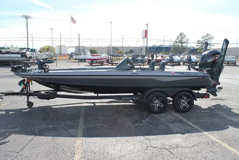 Slide: The Image of 2025 Skeeter ZXR21 bass boat on trailer in parking lot. - 4