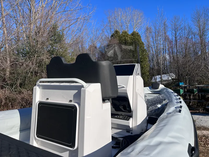 Slide: The Image of 2023 Highfield Sport 700 boat with console and seating, surrounded by trees. - 4