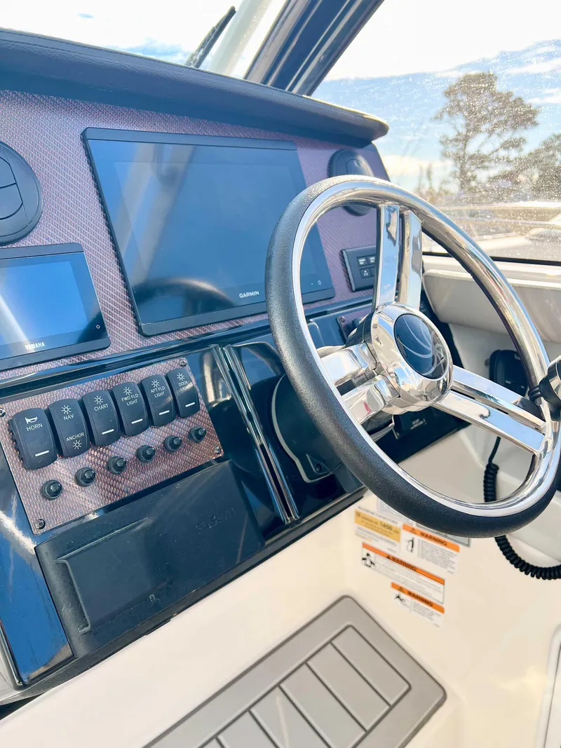 Slide: The Image of 2023 Solara S-250 DC boat dashboard with steering wheel and control panel. - 10