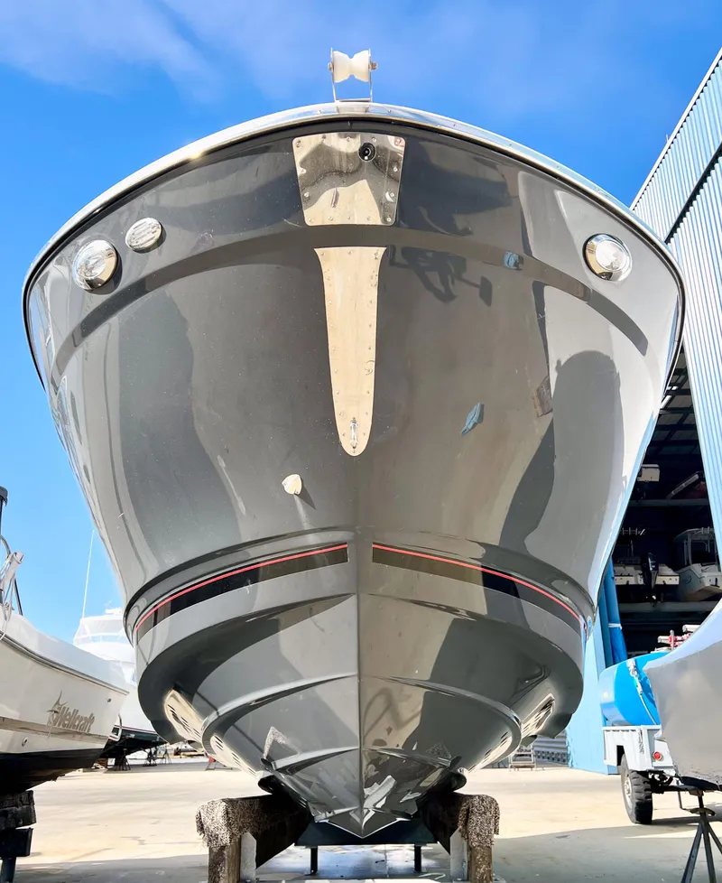 Slide: The Image of 2023 Solara S-250 DC boat with sleek design in a marina setting. - 2