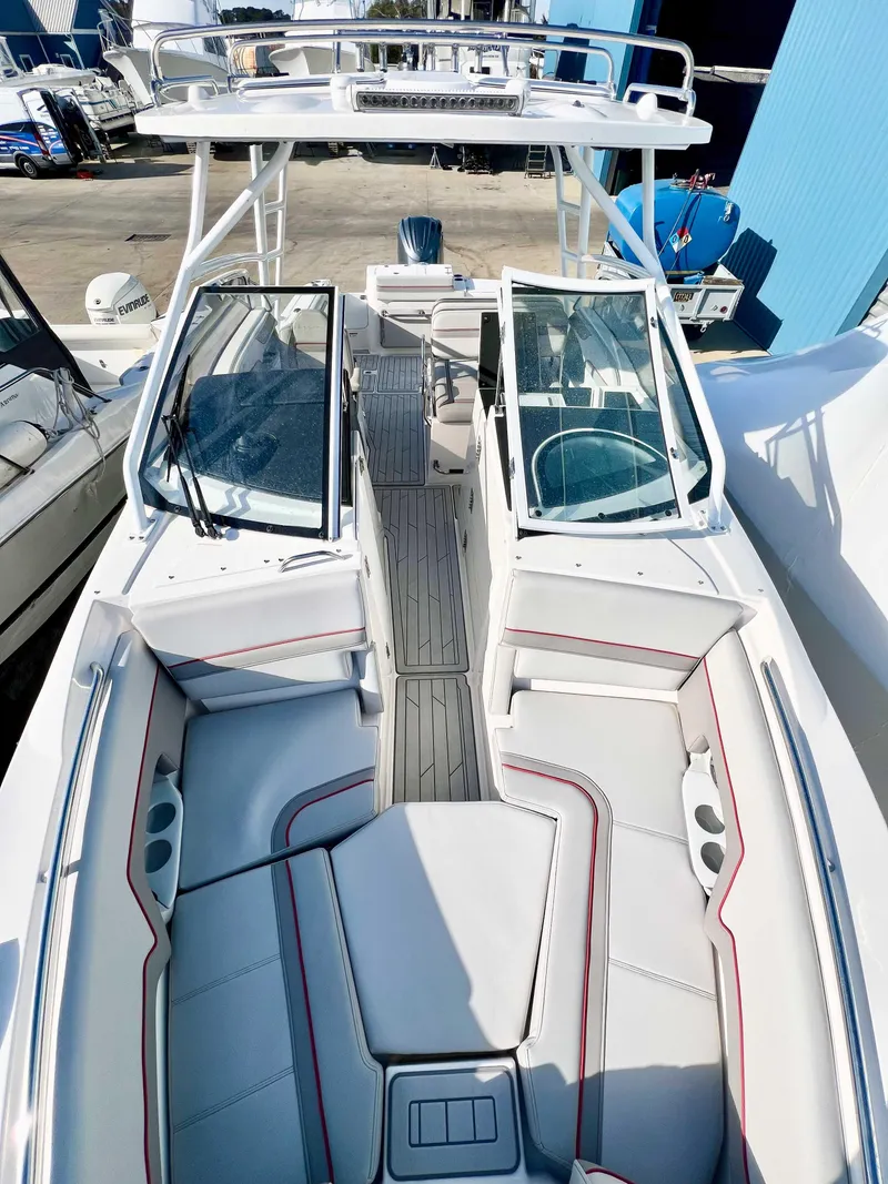Slide: The Image of 2023 Solara S-250 DC boat with open deck and seating, docked at marina. - 26