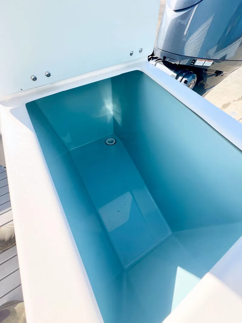 Slide: The Image of 2023 Solara S-250 DC boat livewell with blue interior and outboard motor. - 32