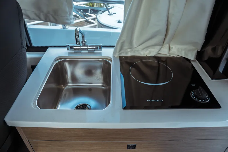 Slide: The Image of Compact kitchen area in 2025 Jeanneau NC 895 Sport Series 2 boat with sink and stove. - 24