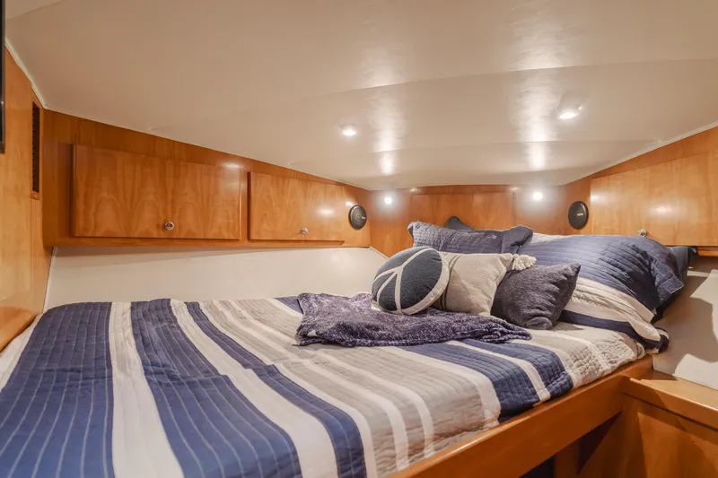 Slide: The Image of Luxurious 2007 Navigator Pilothouse bedroom with striped bedding and wooden cabinetry. - 19