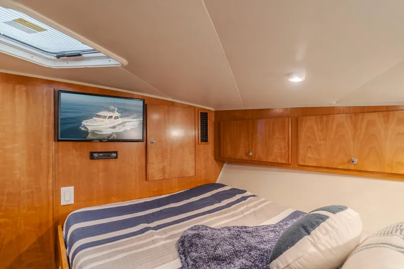 Slide: The Image of Cozy cabin interior of 2007 Navigator Pilothouse yacht with bed, TV, and wooden cabinets. - 20