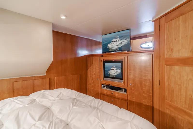 Slide: The Image of Luxurious 2007 Navigator Pilothouse bedroom with wood paneling and dual TVs. - 24