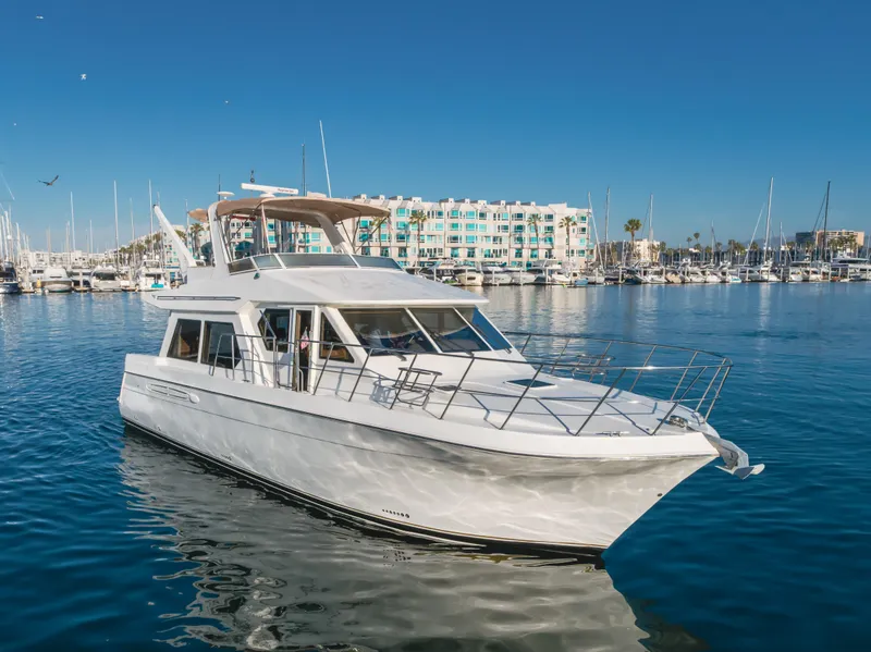 Slide: The Image of 2007 Navigator Pilothouse yacht in marina, clear blue sky, waterfront buildings in background. - 3
