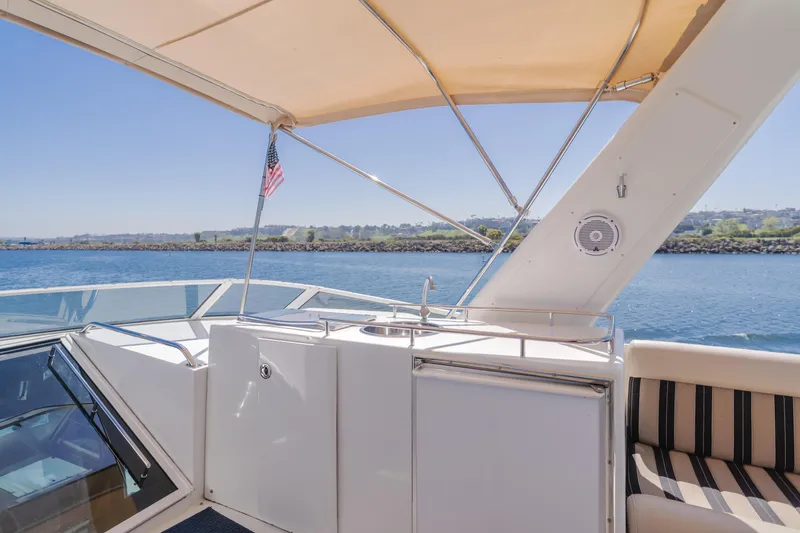 Slide: The Image of 2007 Navigator Pilothouse yacht deck with canopy, overlooking serene water and shoreline. - 30