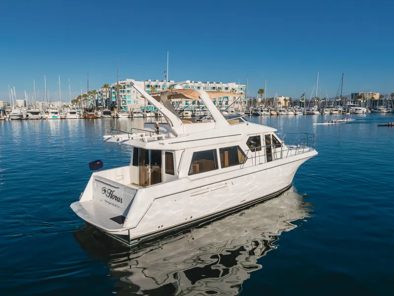 Slide: The Image of 2007 Navigator Pilothouse yacht in marina, clear blue sky, calm water, docked boats in background. - 7