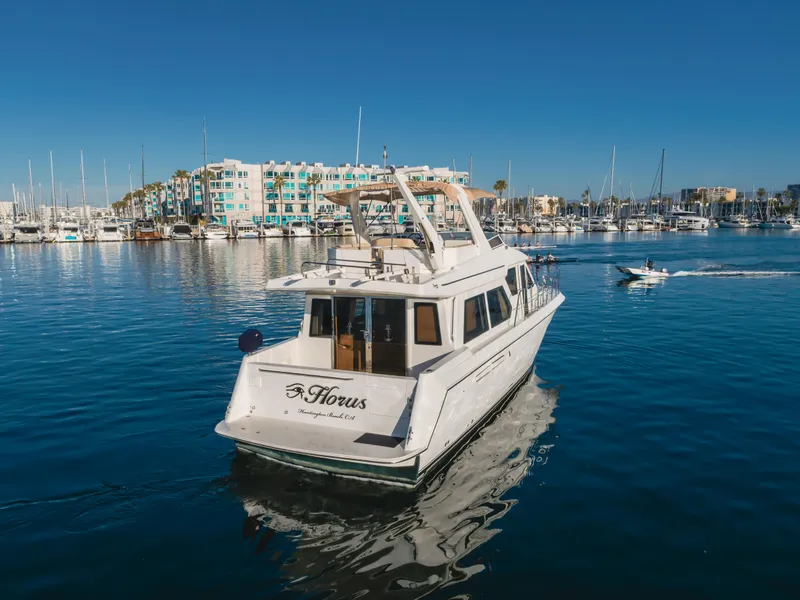 Slide: The Image of 2007 Navigator Pilothouse yacht cruising in a marina with waterfront buildings in the background. - 8