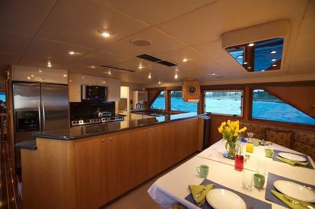 Slide: The Image of Luxurious 1991 Broward 105 yacht interior with modern kitchen and dining area. - 26