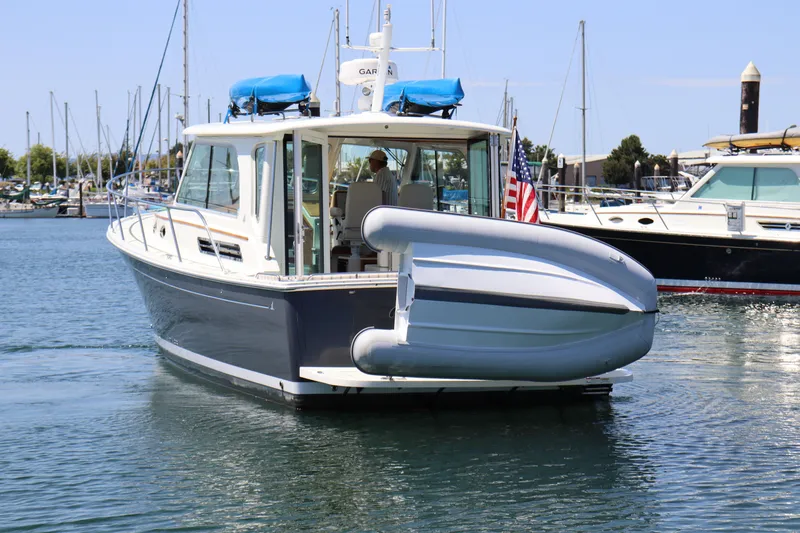 Slide: The Image of 2020 Back Cove 37 boat in marina, featuring sleek design and inflatable dinghy on deck. - 2