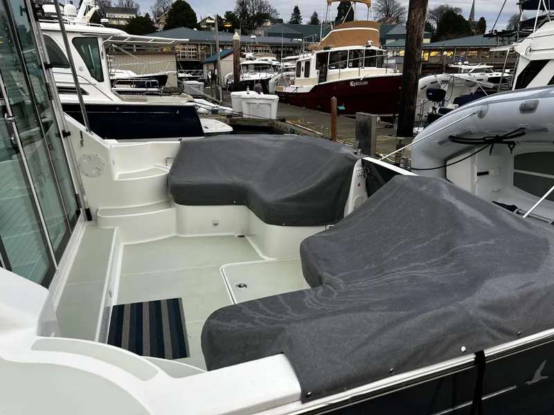 Slide: The Image of 2020 Back Cove 37 boat with covered seating area in a marina setting. - 20