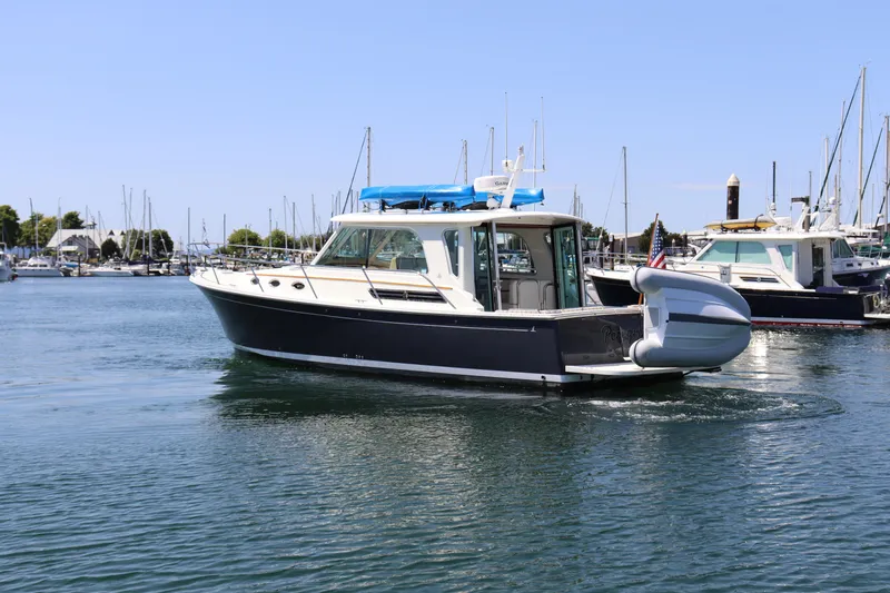 Slide: The Image of 2020 Back Cove 37 boat docked in a marina, surrounded by other vessels. - 3