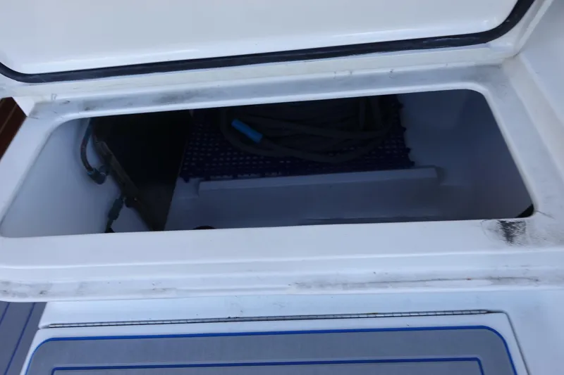 Slide: The Image of Storage compartment on a 2001 Luhrs 36 Convertible boat, open with visible ropes inside. - 14